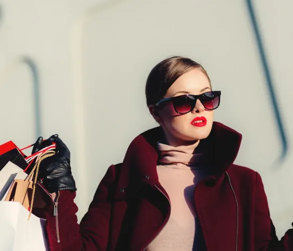 A stylish shopper holding shopping bags after a modern shopping trip